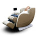 Woman relaxing in beige and white zero-gravity massage chair with tablet holder in reclined position