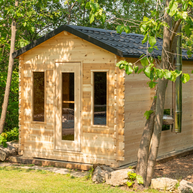 "Georgian Cabin Sauna with Changeroom crafted from Eastern White Cedar, featuring large windows and a durable black matte steel roof, perfect for enhancing any home or cottage with a luxurious wellness space."