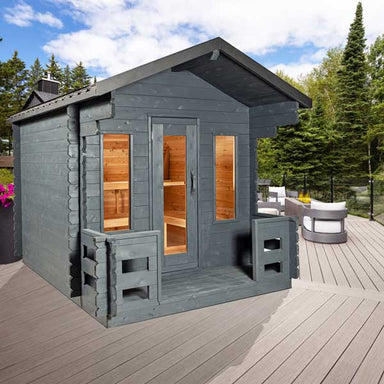 "Georgian Cabin Sauna from Leisurecraft, crafted from Eastern White Cedar with a black steel roof and front porch, featuring large windows and versatile seating, ideal for integrating into cottages and modern homes alike."