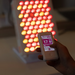 Handheld remote with red light therapy device in background