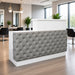 White salon reception desk with gray tuft in modern salon